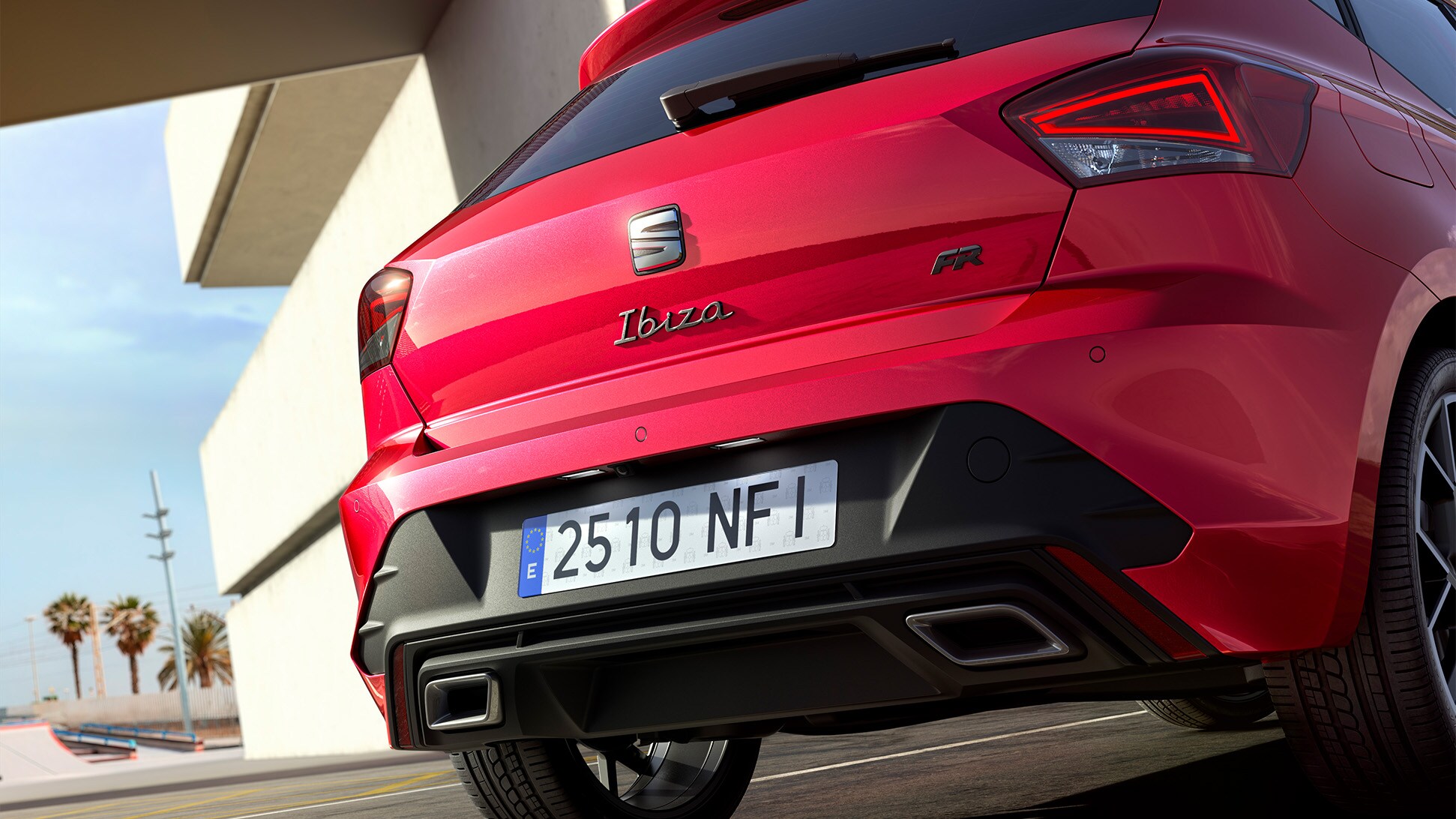 Rear view of a seat ibiza in red, parked outdoors. 