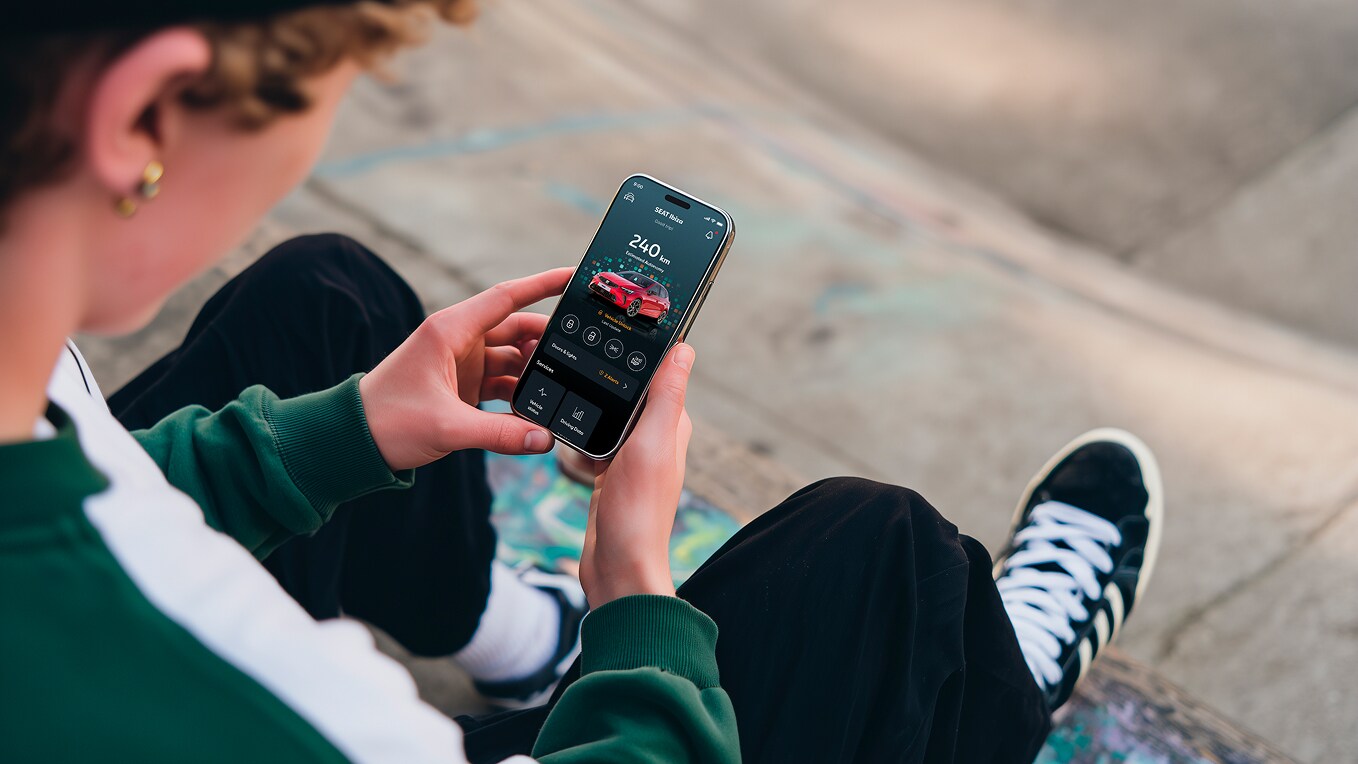 Personne tenant son smartphone et utilisant les fonctions à distance du siège