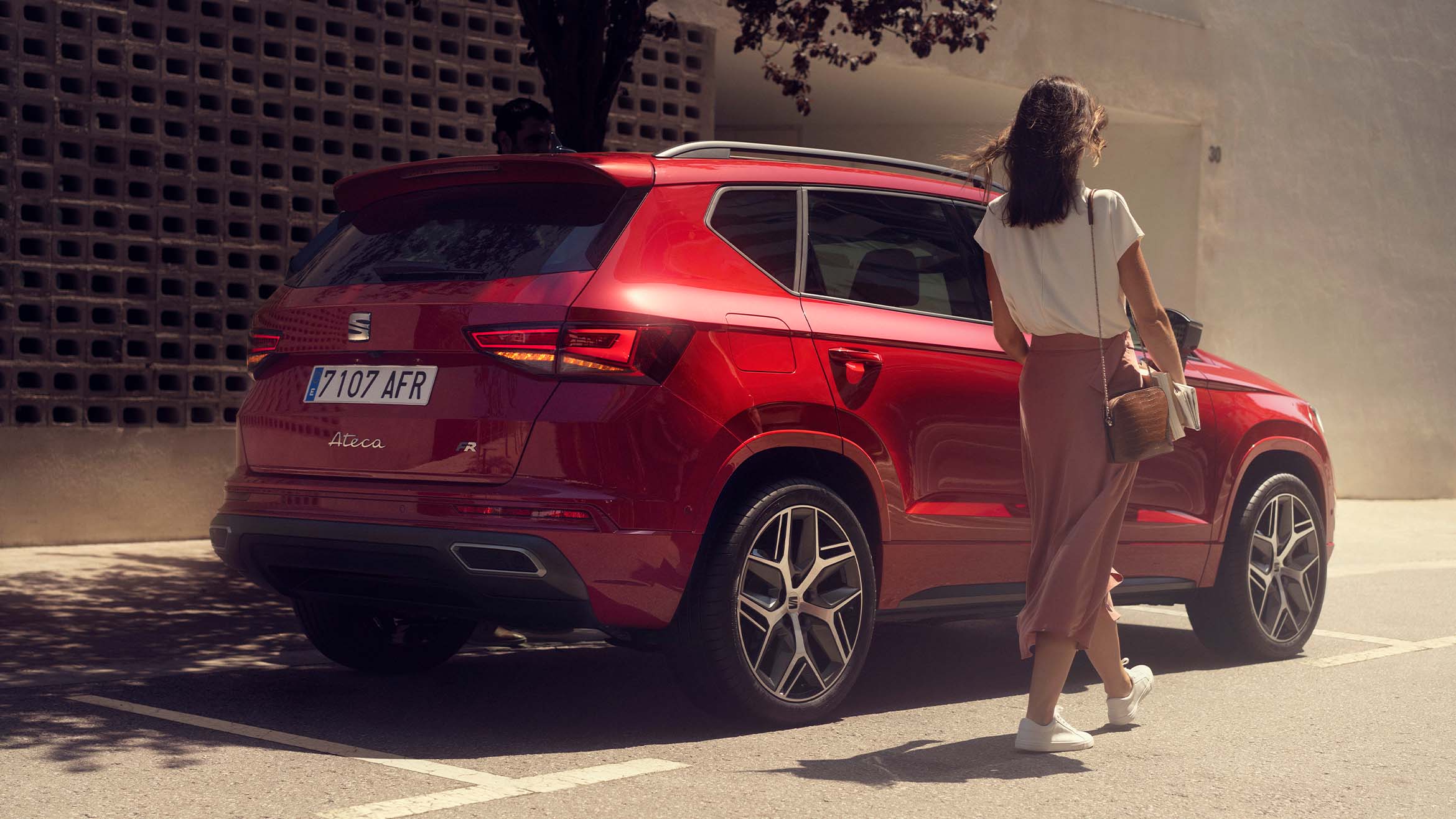 woman-walking-next-to-seat-ateca-velvet-red-colour