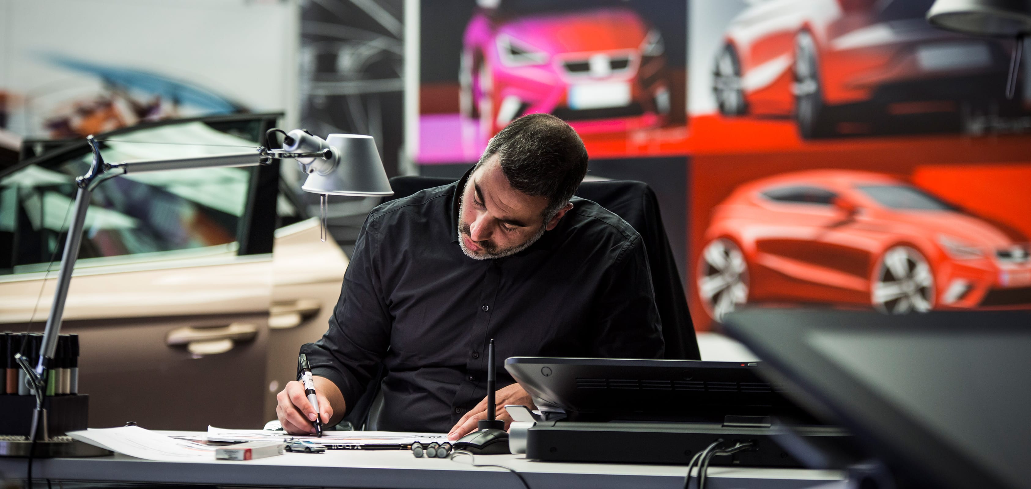 Homme dessinant à son bureau avec un marqueur.