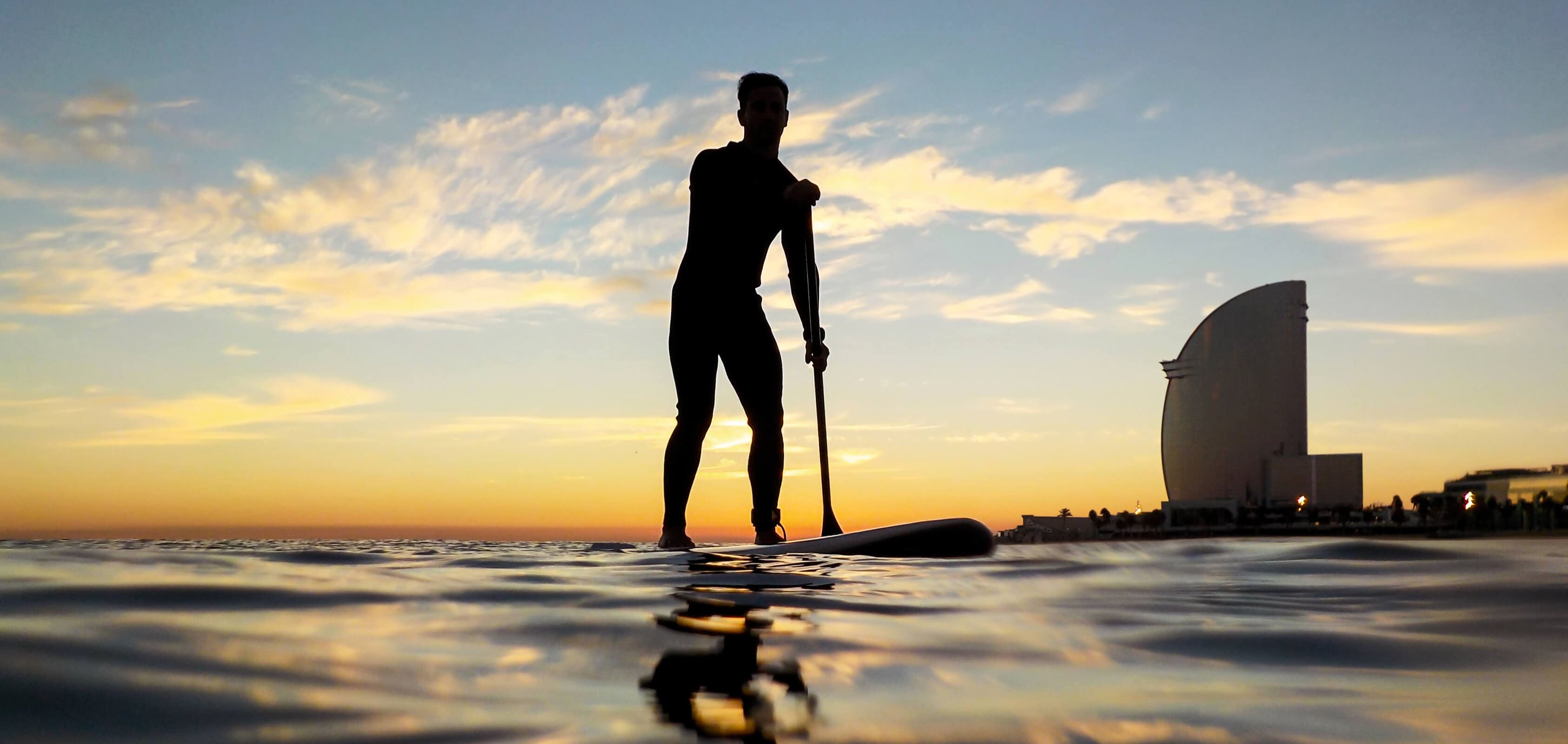 silhouette d'un homme qui fait du paddle